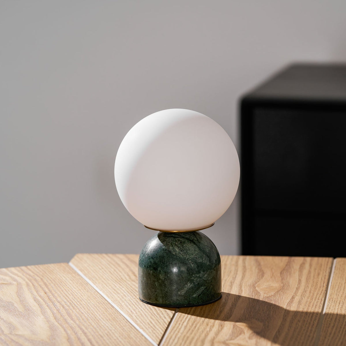 Lámpara de mesita Dunela con globo opal y base de mármol sobre una mesa de madera – imagen 14