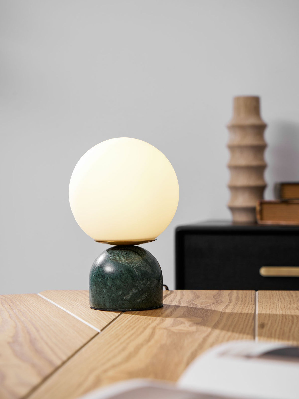 Lámpara de mesita Dunela con globo opal y base de mármol sobre una mesa de madera – imagen 15
