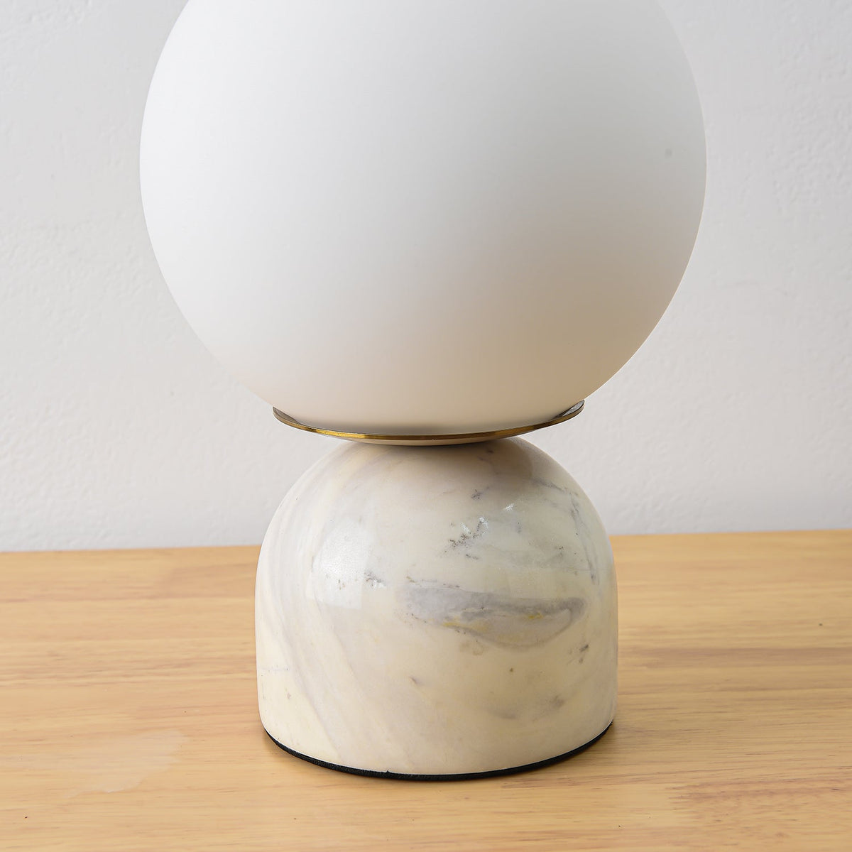 Lámpara de mesita Dunela con globo opal y base de mármol sobre una mesa de madera – imagen 7