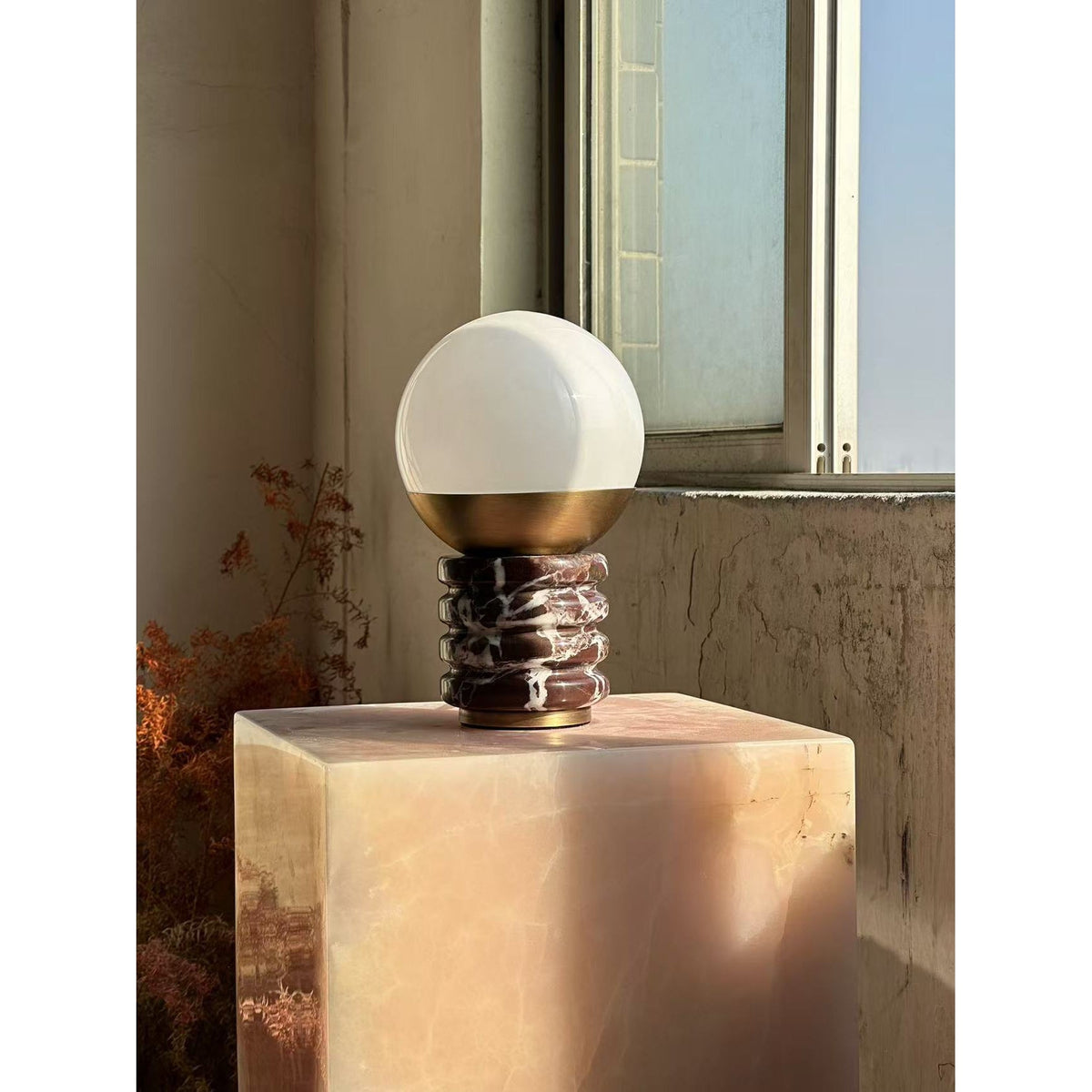 Lámpara de mesa de mármol Sferina – sobre un pedestal junto a la ventana