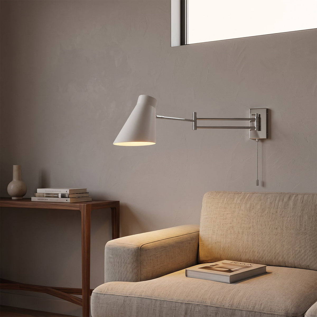 Aplique de pared con brazo extensible Kurela – pantalla blanca sobre un sofá