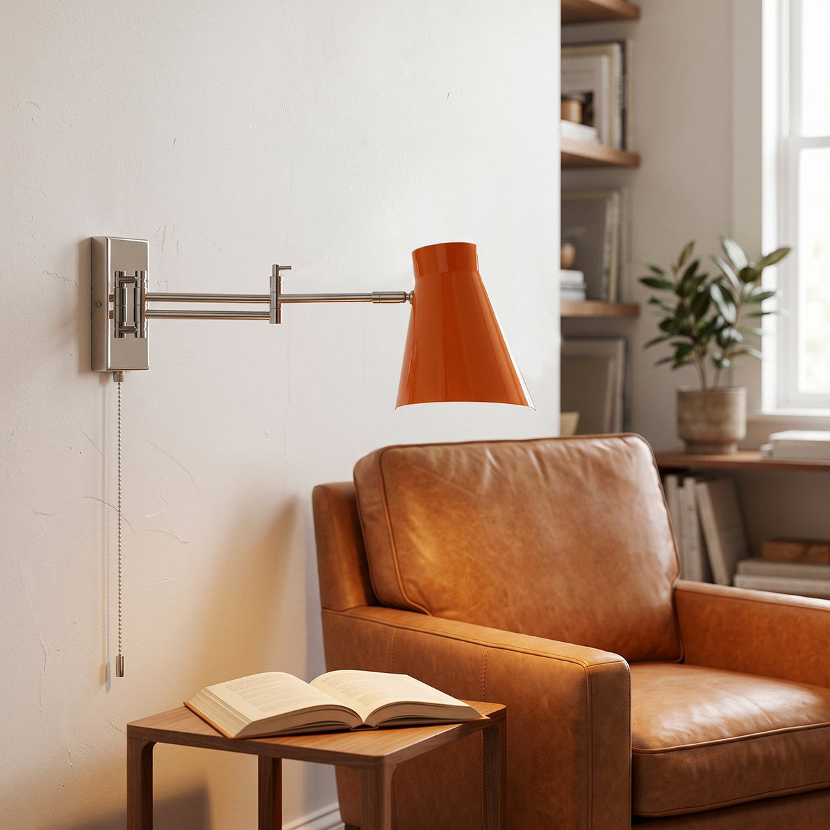 Aplique de pared con brazo extensible Kurela – pantalla naranja en un rincón de lectura