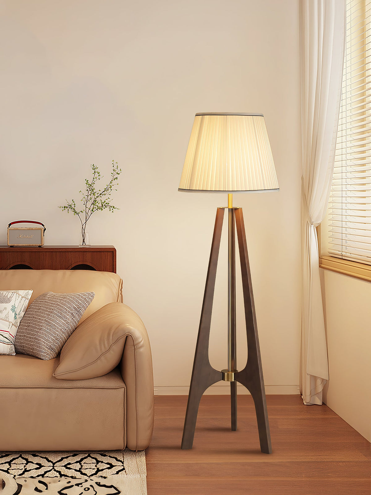 Lámpara de pie trípode de madera con pantalla plisada blanca Sabina – en un rincón del salón junto a un sofá
