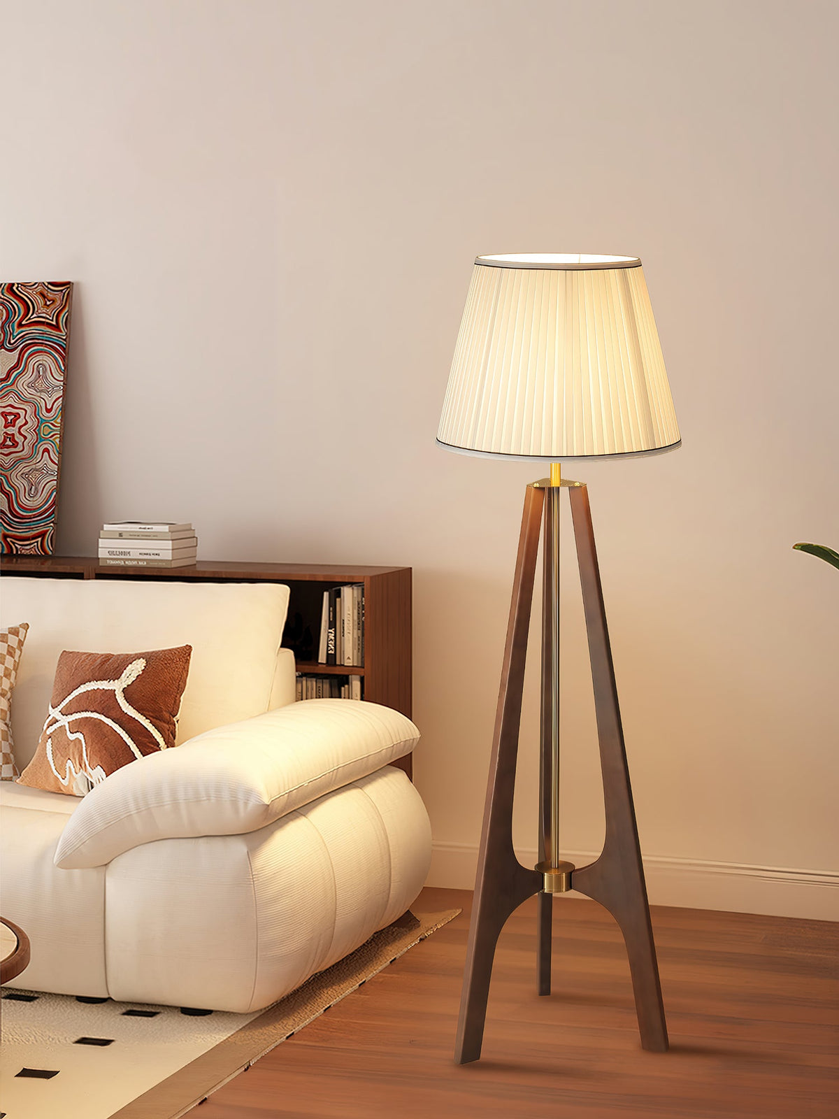 Lámpara de pie trípode de madera con pantalla plisada blanca Sabina – junto a un sofá blanco