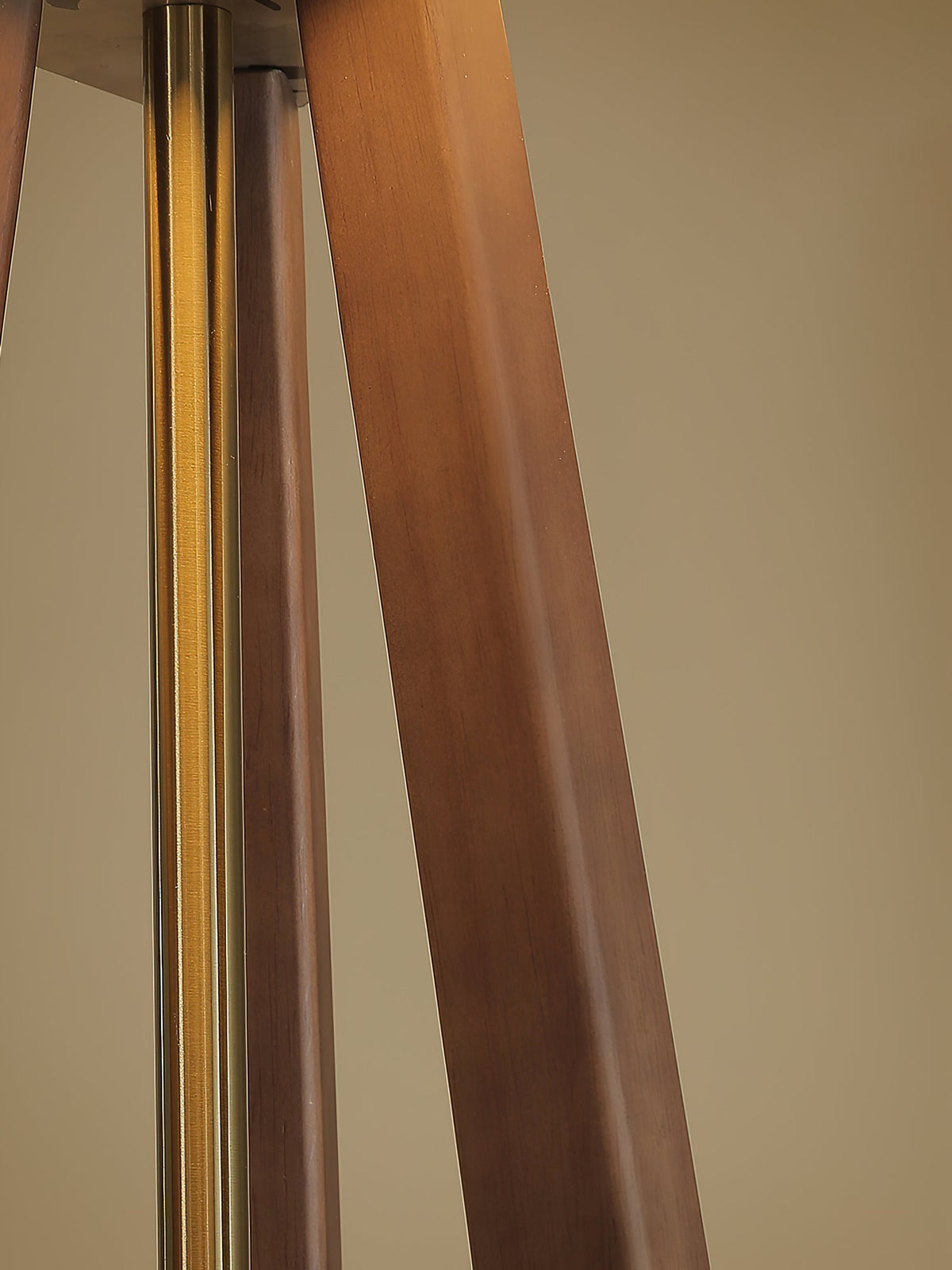 Lámpara de pie trípode de madera con pantalla plisada blanca Sabina – detalle de la unión dorada de las patas de madera