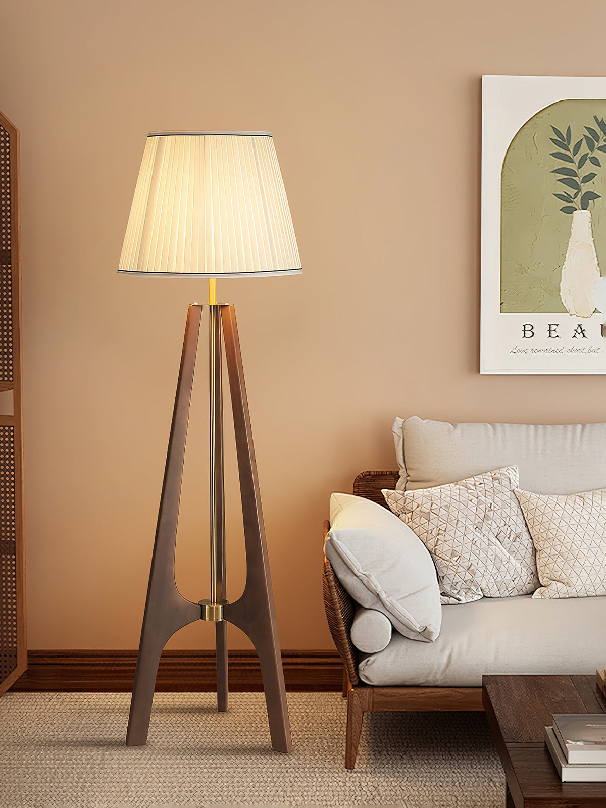 Lámpara de pie trípode de madera con pantalla plisada blanca Sabina – junto a un sofá blanco y un cuadro