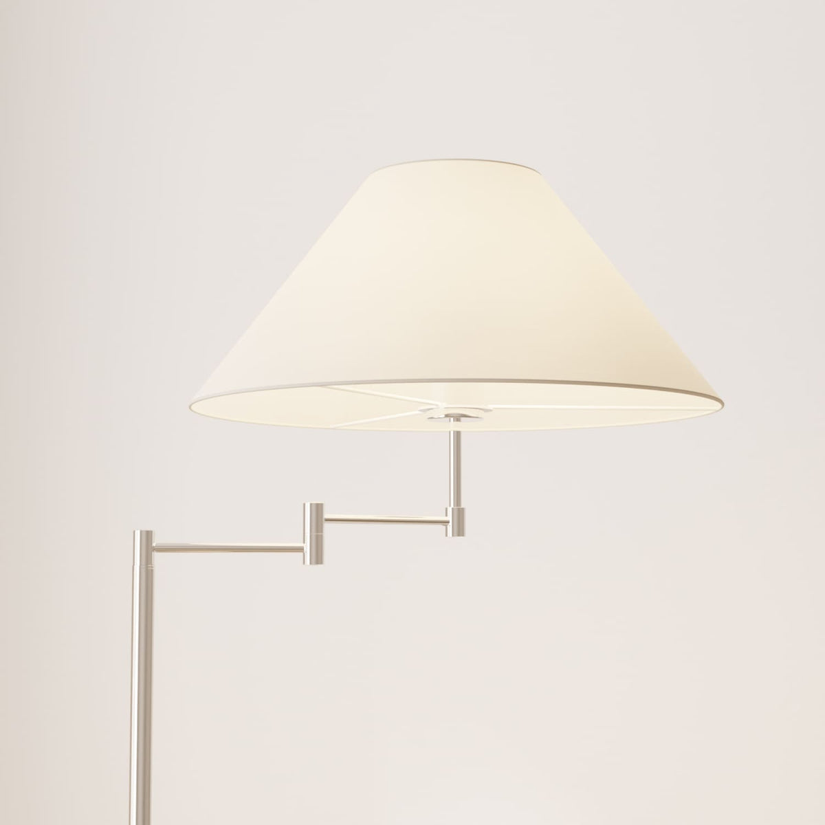Lámpara de pie con brazo giratorio Pavena junto a un sillón – imagen 3