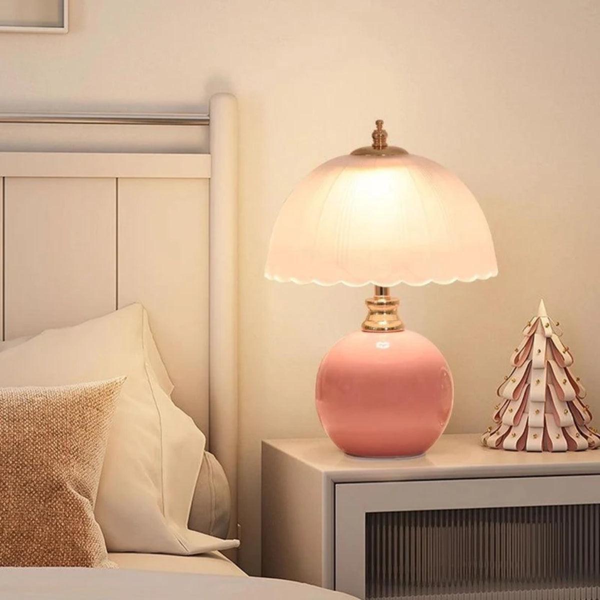 Lámpara de mesita de noche Rizonda – con base rosa en una mesilla de noche