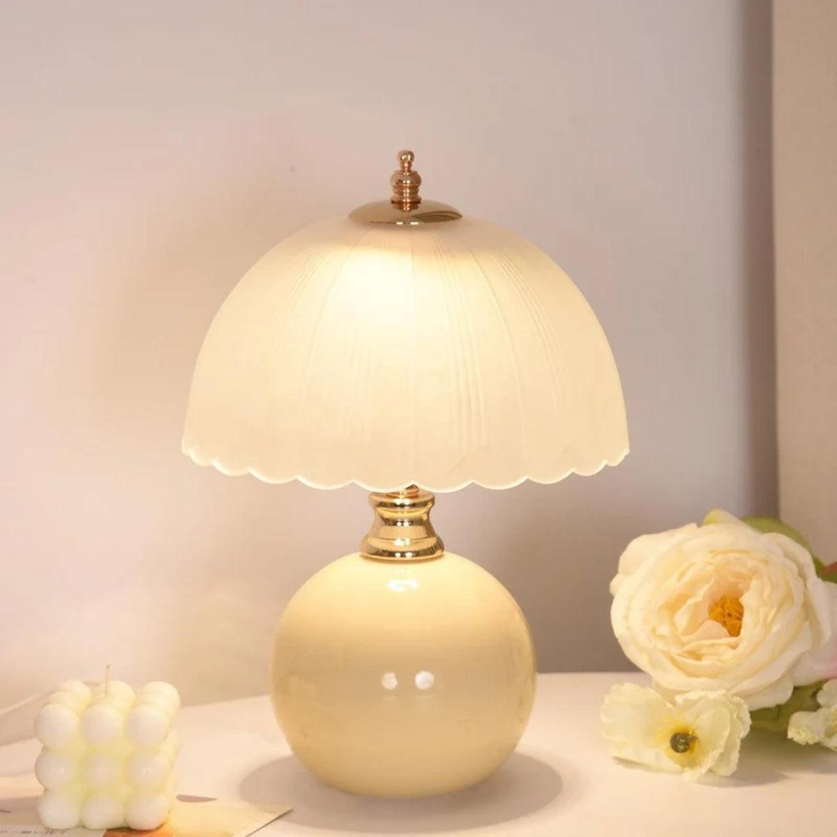 Lámpara de mesita de noche Rizonda – con base amarilla junto a una flor