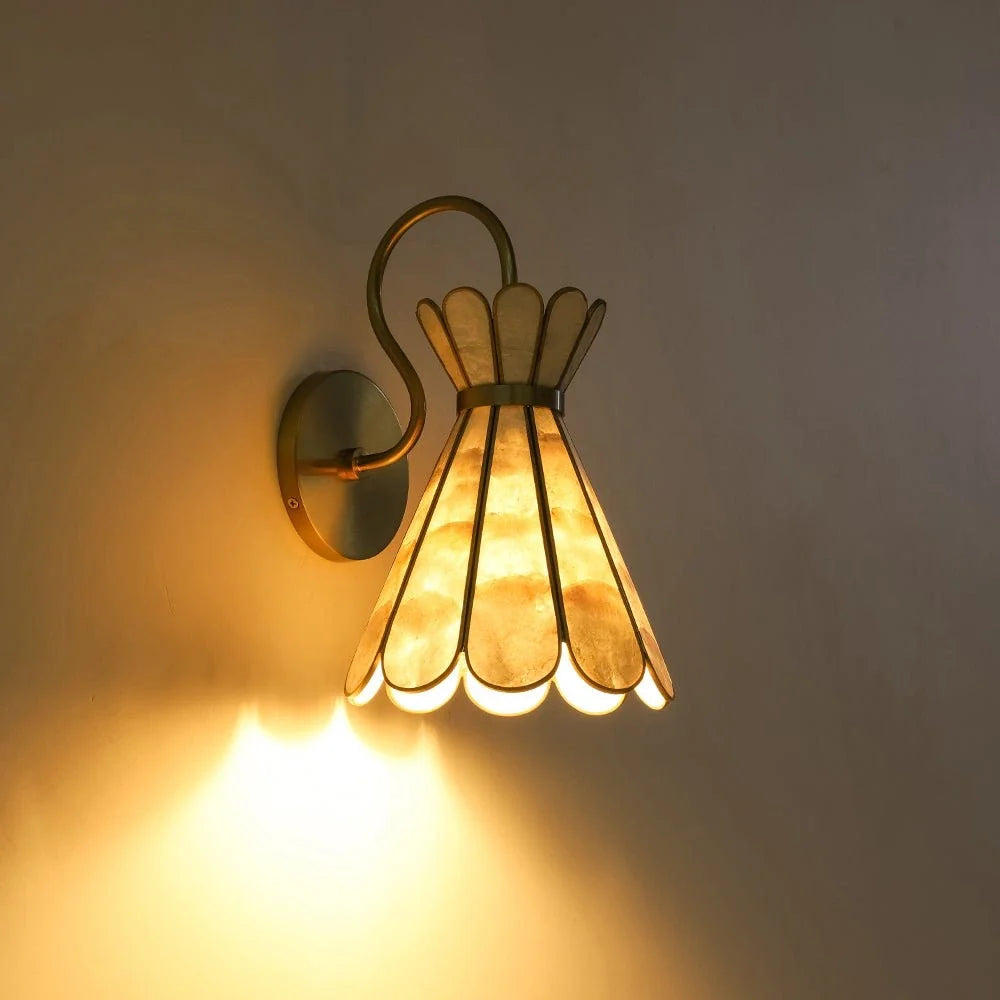 Aplique de pared Unacela de concha capiz – luz cálida sobre pared oscura