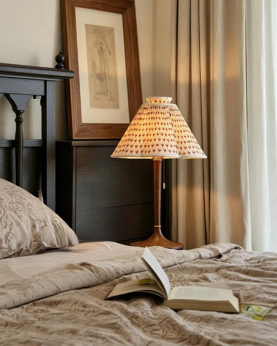 Lámpara de mesa plisada Tulipela – junto a la cama con un libro