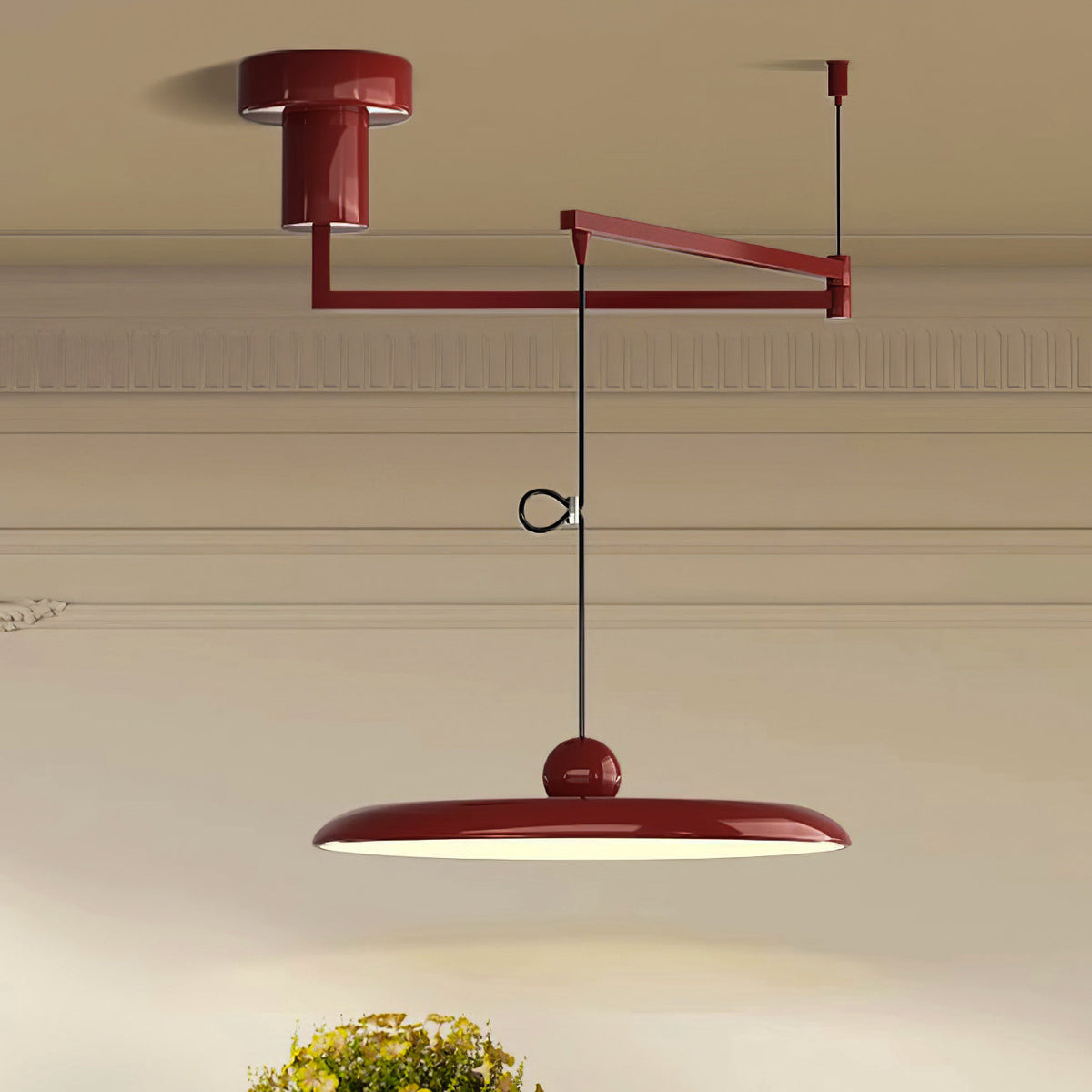 Lámpara colgante LED con brazo giratorio Balancia – en rojo sobre una mesa