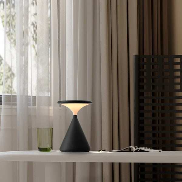Lámpara de mesa recargable Relina – en negro junto a una ventana