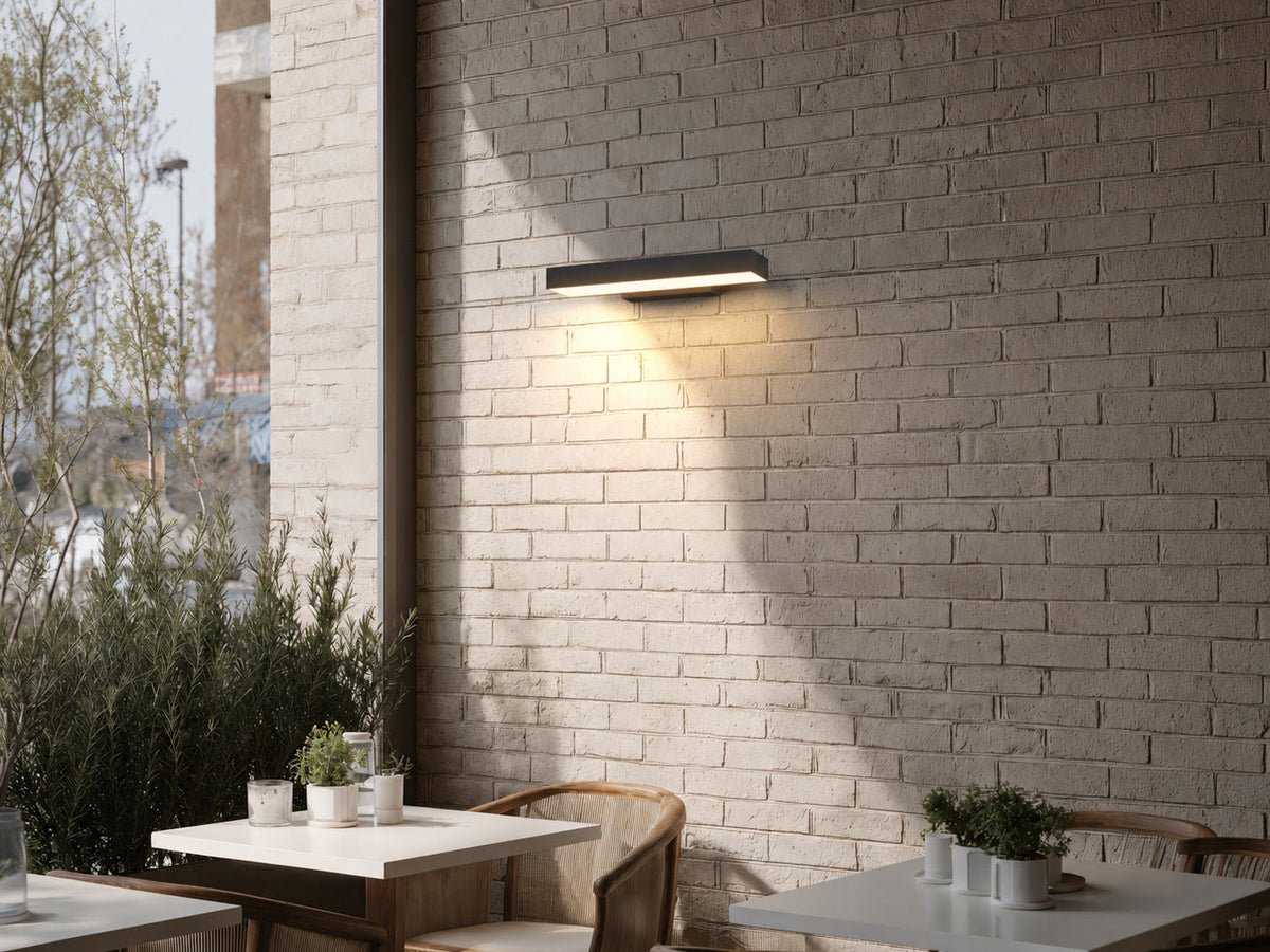 Aplique de pared exterior Kilera – en una pared de ladrillo junto a la terraza