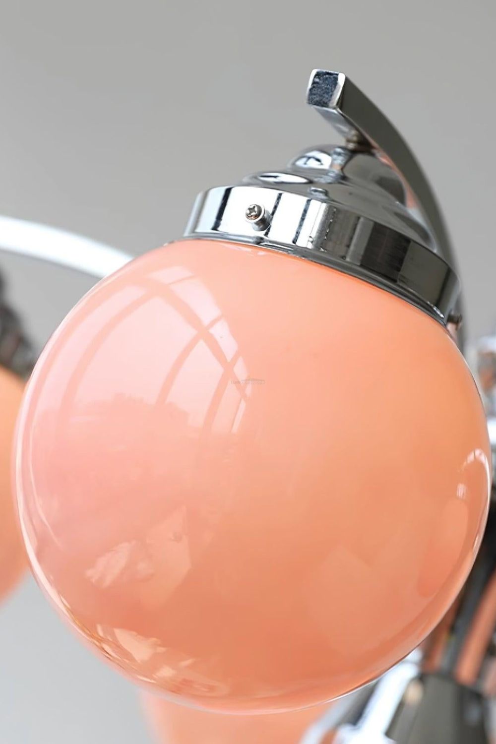 Lámpara de araña art déco Decolia – detalle del globo rosa y el brazo cromado