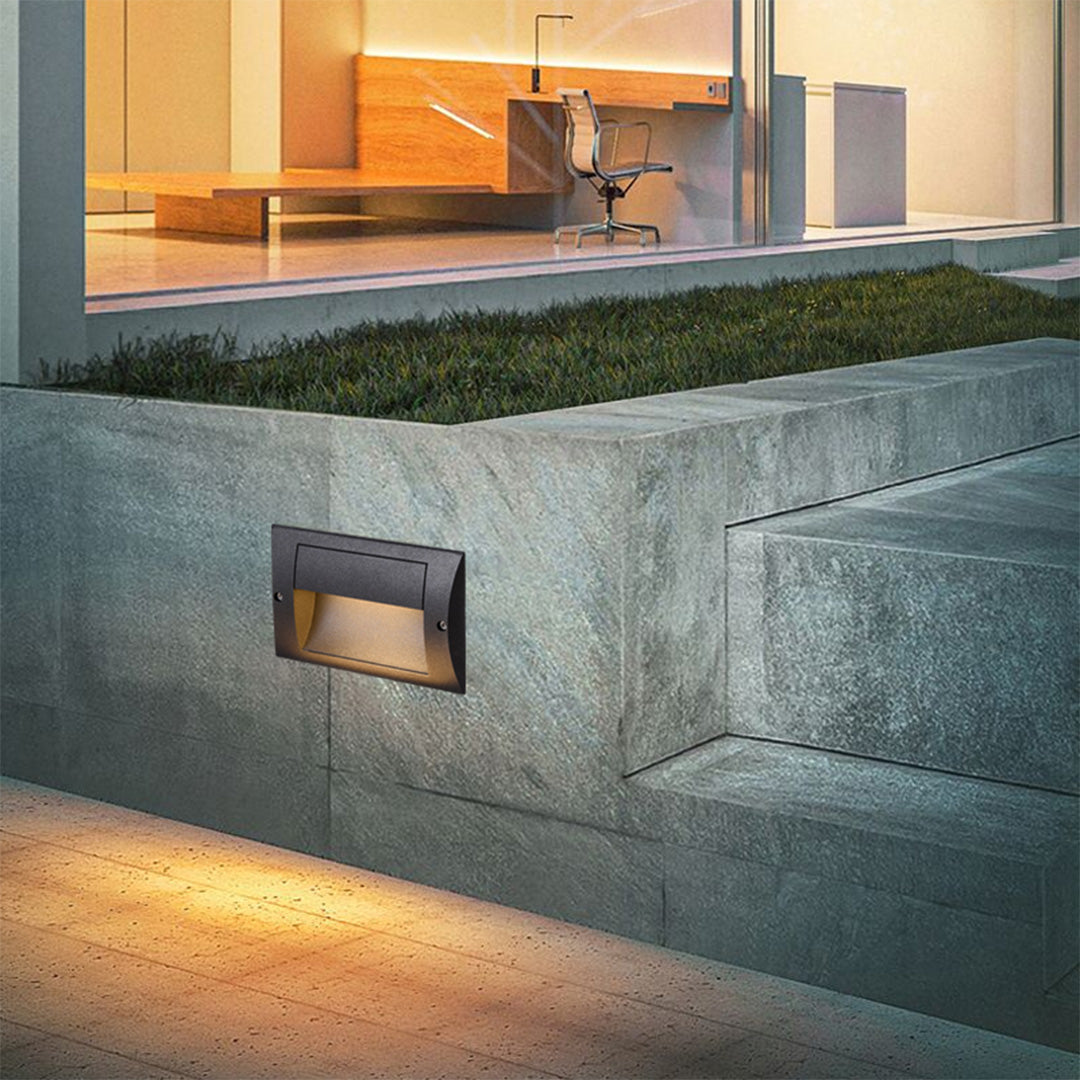 Luz de escalera empotrable exterior Isenda – empotrada en un muro de piedra junto al césped