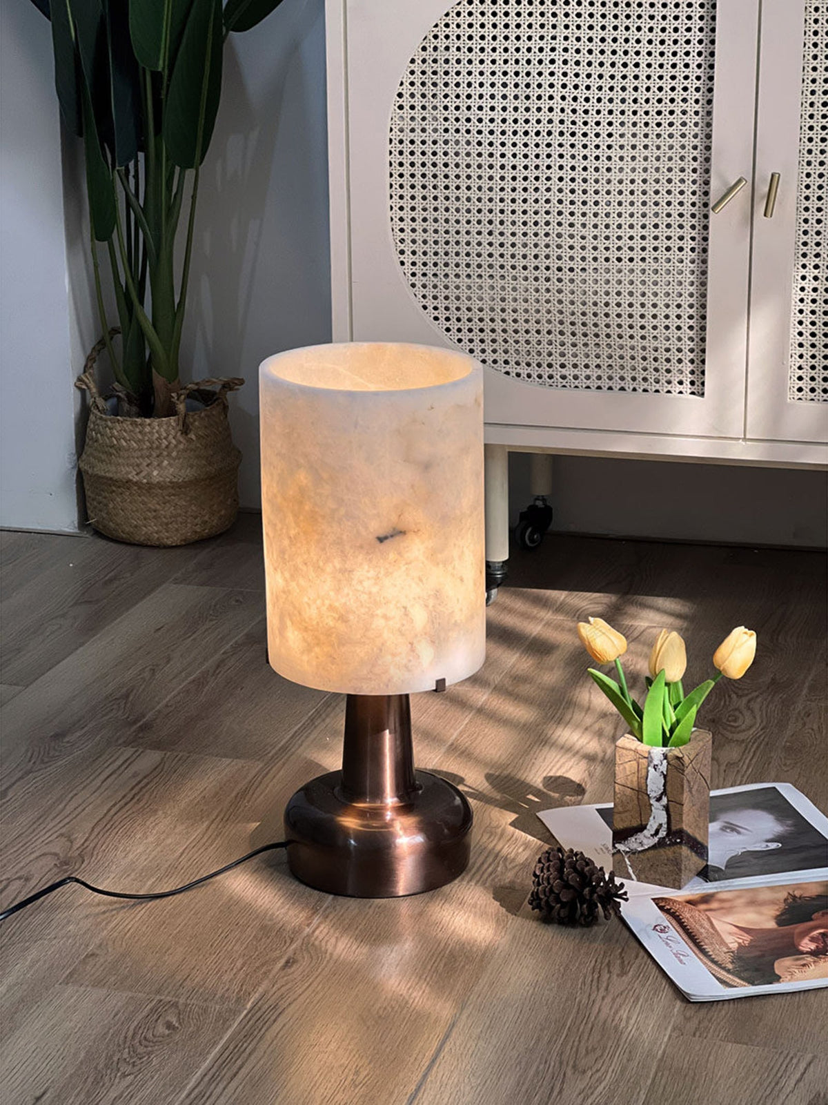 Lámpara de mesa de alabastro Merola sobre una mesa auxiliar junto a un sillón de cuero – imagen 2