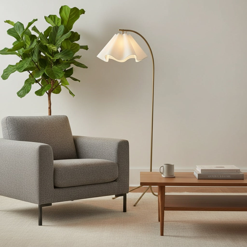Lámpara de pie arco con pantalla ondulada de tela Flurena junto a un sillón en un rincón de lectura – imagen 6