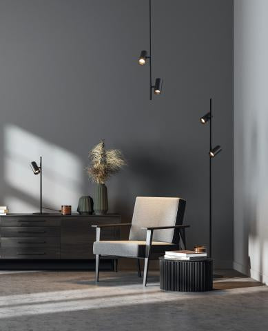 Lámpara de pie Tesaro con dos focos orientables – negra en un salón moderno