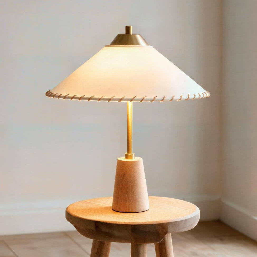 Lámpara de mesa de latón y madera con pantalla cónica Cumbela sobre una mesita de noche – imagen 13