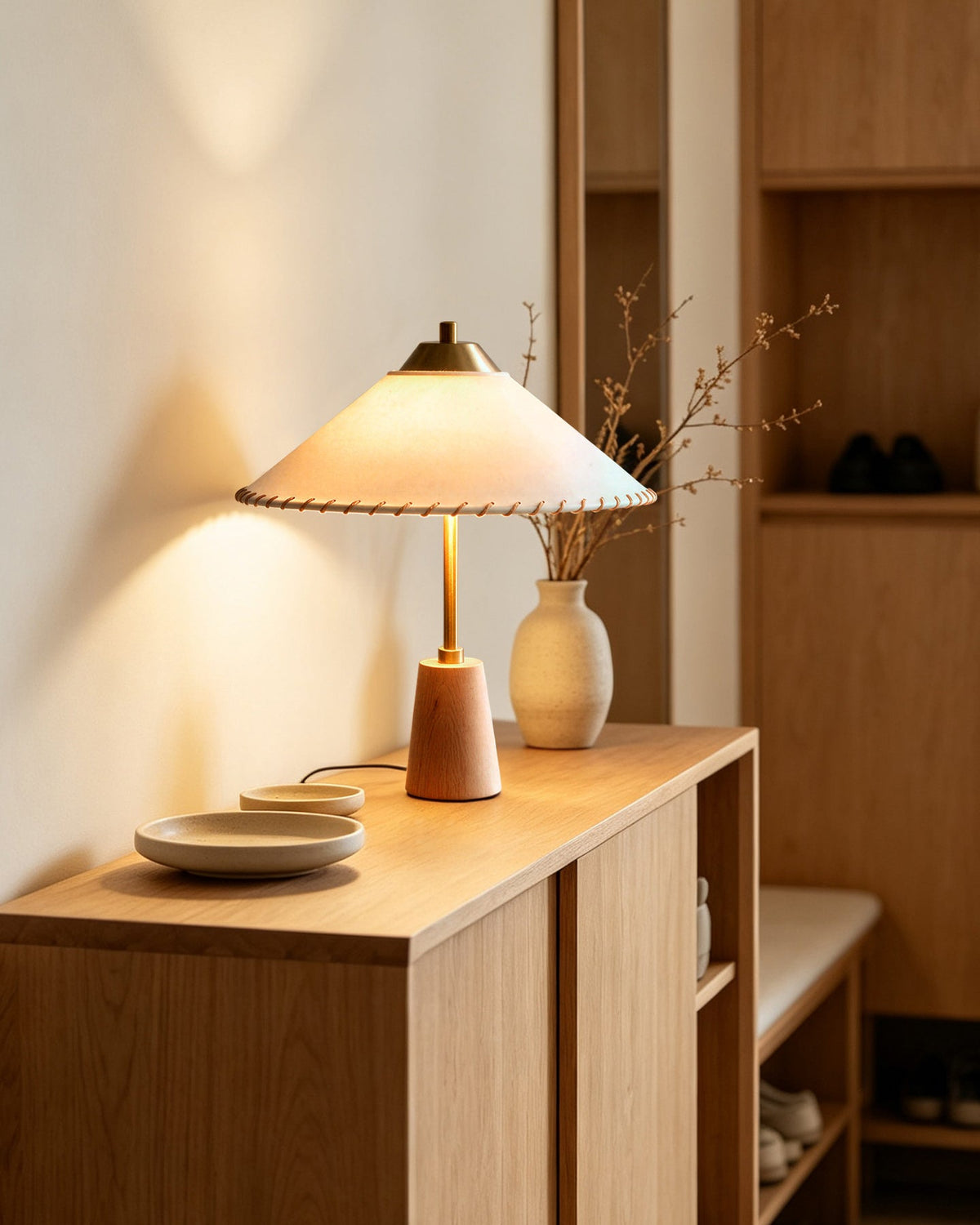 Lámpara de mesa de latón y madera con pantalla cónica Cumbela sobre una mesita de noche – imagen 6