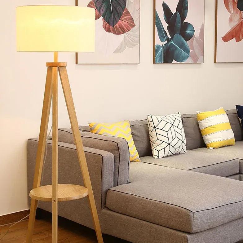 Lámpara de pie trípode de madera con estante y pantalla cilíndrica Jorvia – vista principal