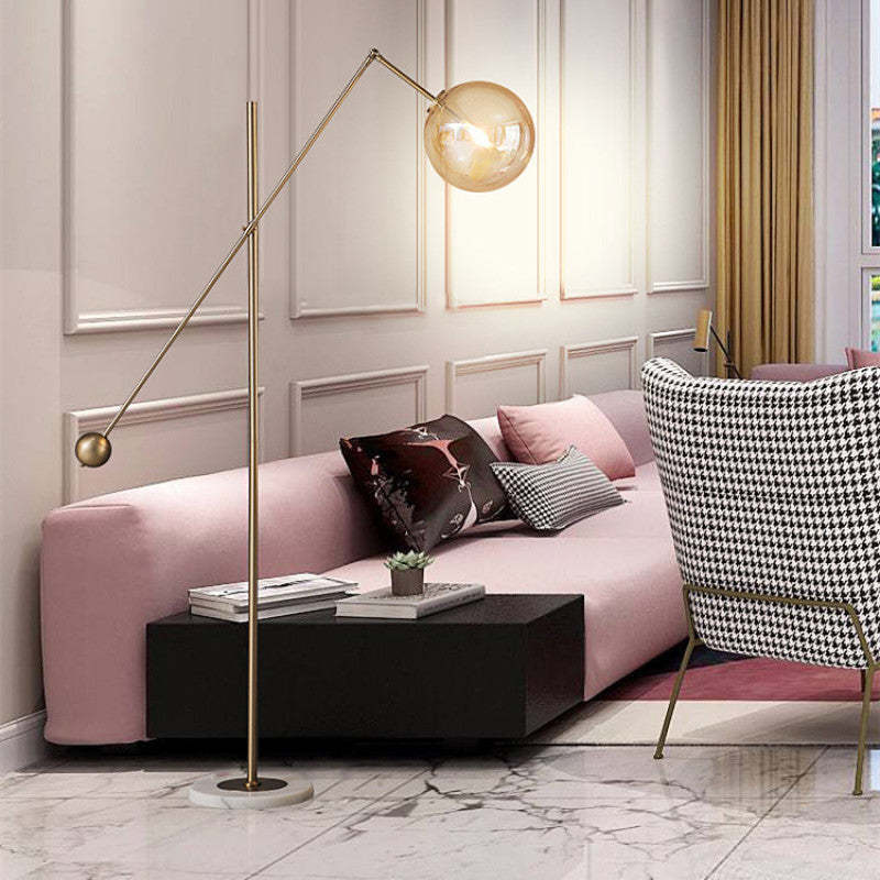 Lámpara de pie de latón Romana con globo ámbar en un salón elegante – imagen 2