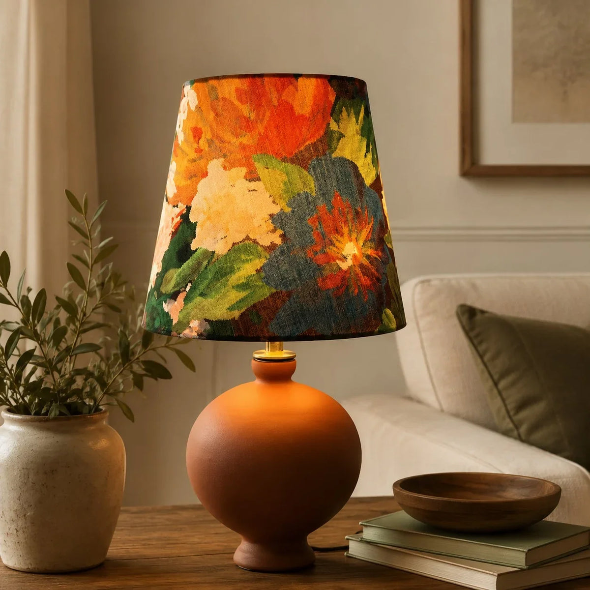Lámpara de mesa de cerámica Vergela – con pantalla floral naranja en una mesa auxiliar