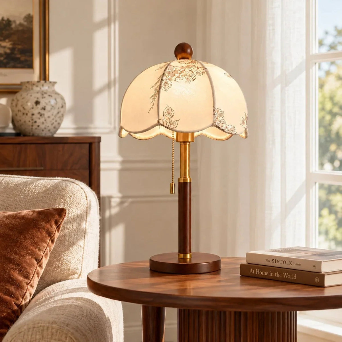 Lámpara de mesa vintage de tela Evelia – encendida sobre una mesa redonda junto a la ventana