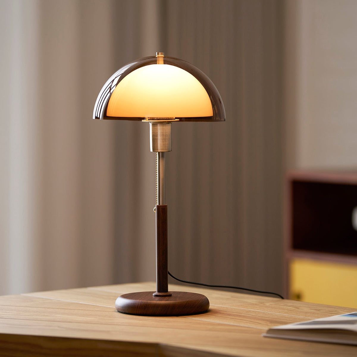Lámpara de mesa retro Fambra – ámbar sobre una mesa de madera clara