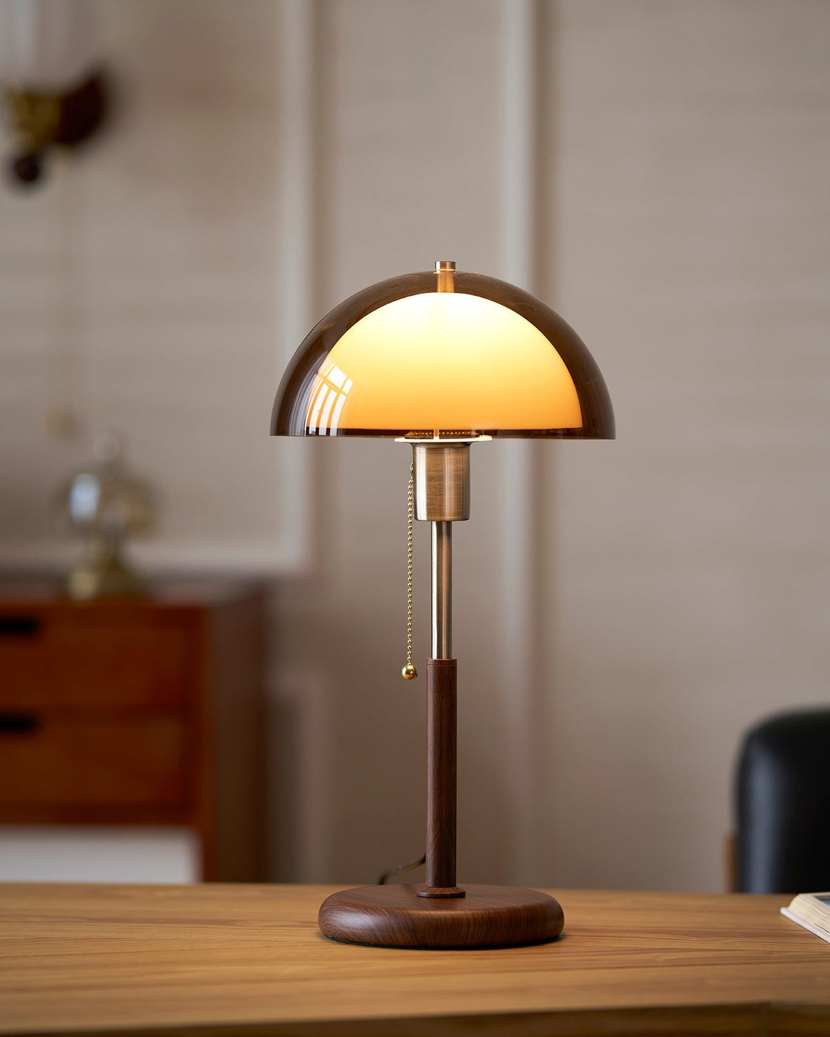 Lámpara de mesa retro Fambra – ámbar encendida sobre un escritorio