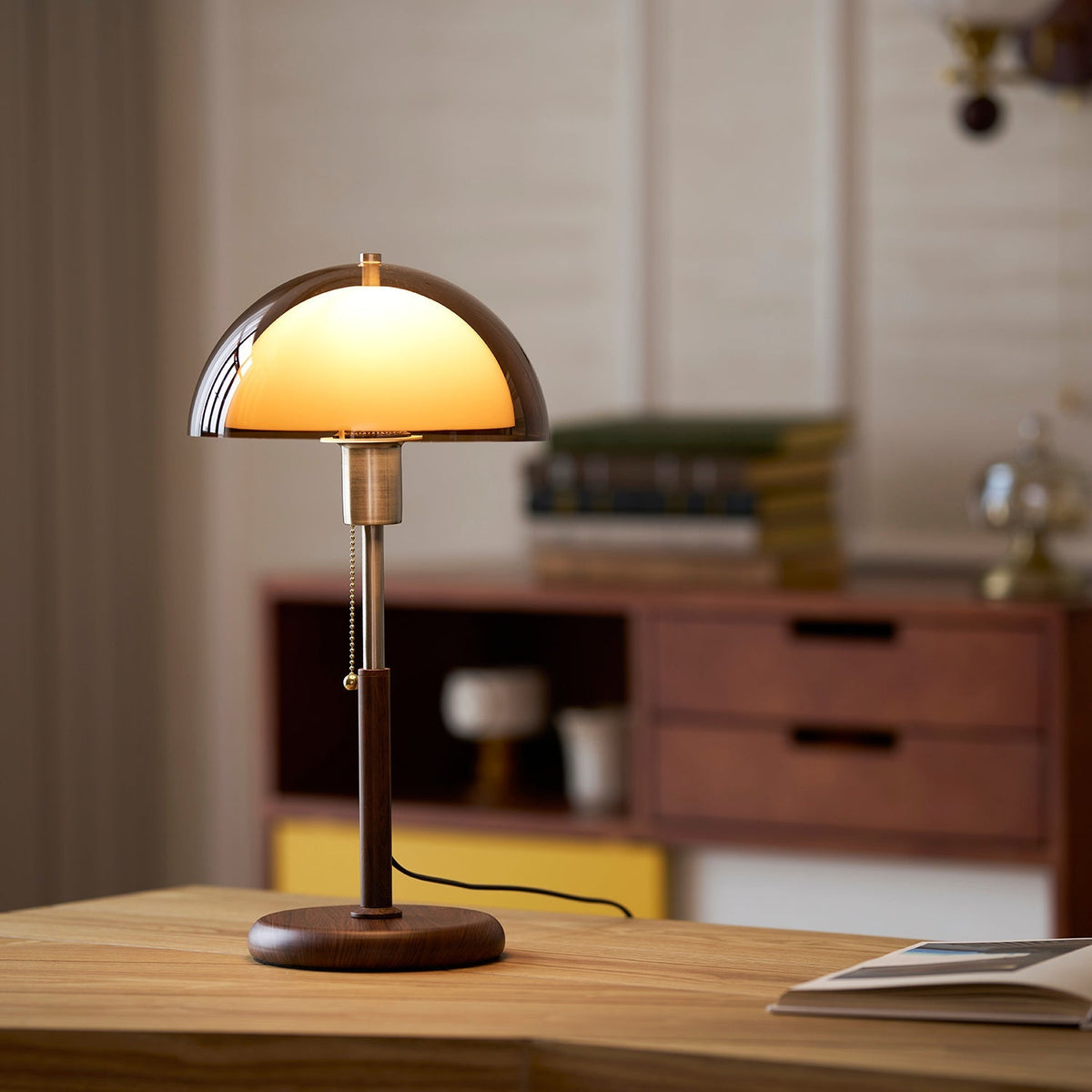 Lámpara de mesa retro Fambra – ámbar en un escritorio con aparador al fondo