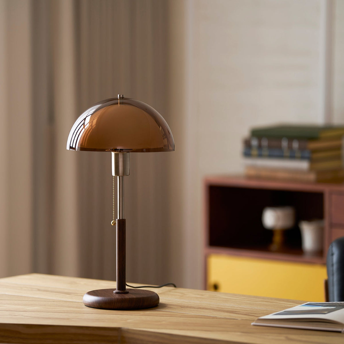 Lámpara de mesa retro Fambra – ámbar junto a un armario amarillo