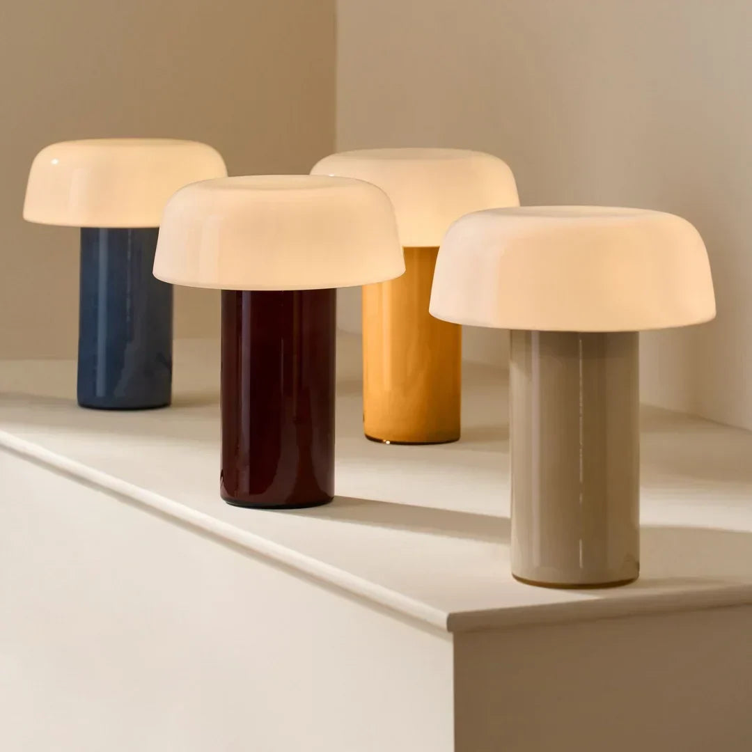 Lámpara de mesa seta de vidrio Feluna – varias lámparas seta en distintos colores sobre una repisa