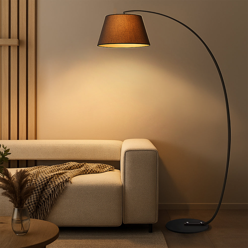 Lámpara de pie de arco Zircelo junto a un sofá en un salón acogedor – imagen 6