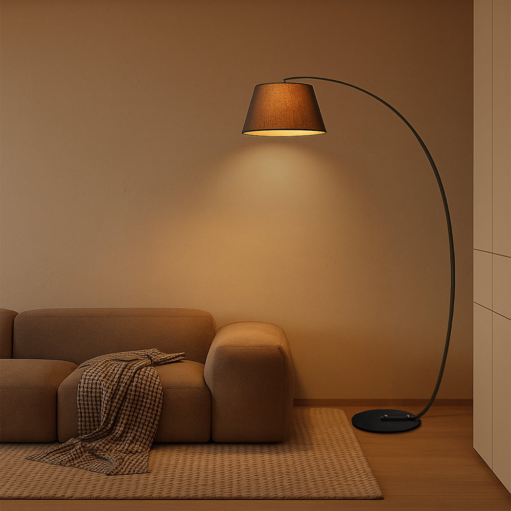 Lámpara de pie de arco Zircelo junto a un sofá en un salón acogedor – imagen 4
