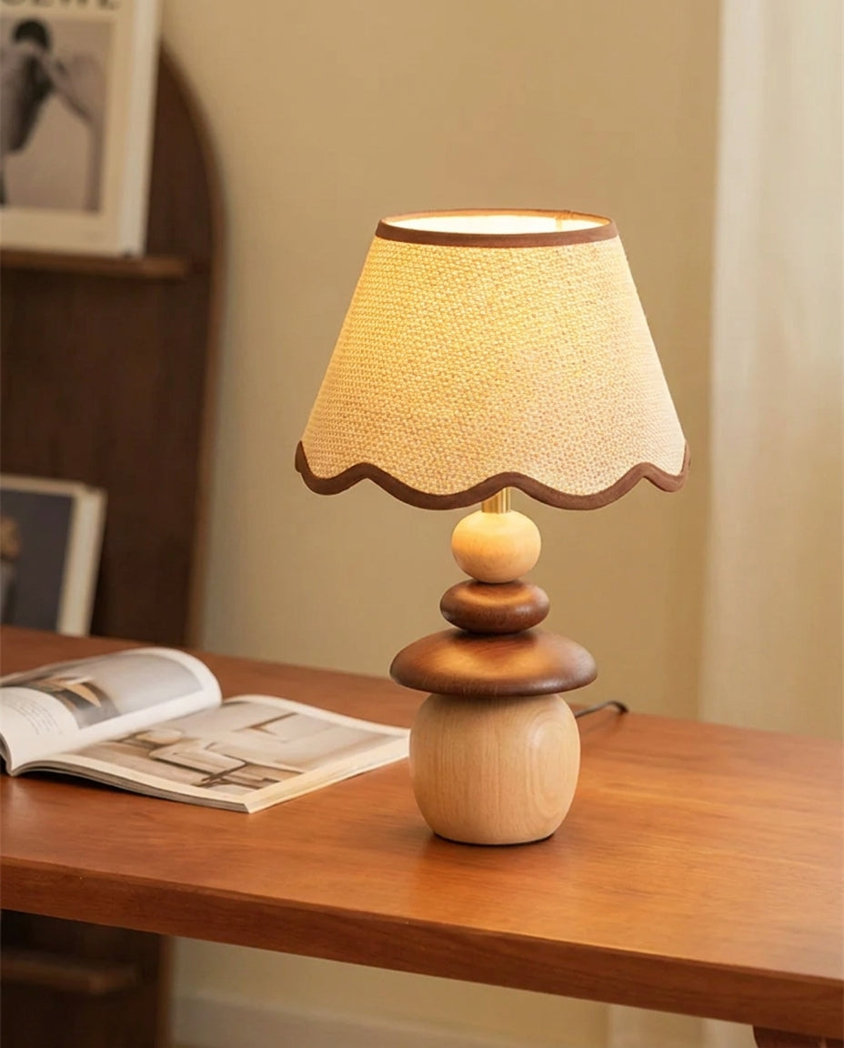 Lámpara de mesa de madera Frenela – sobre una mesa con revista abierta