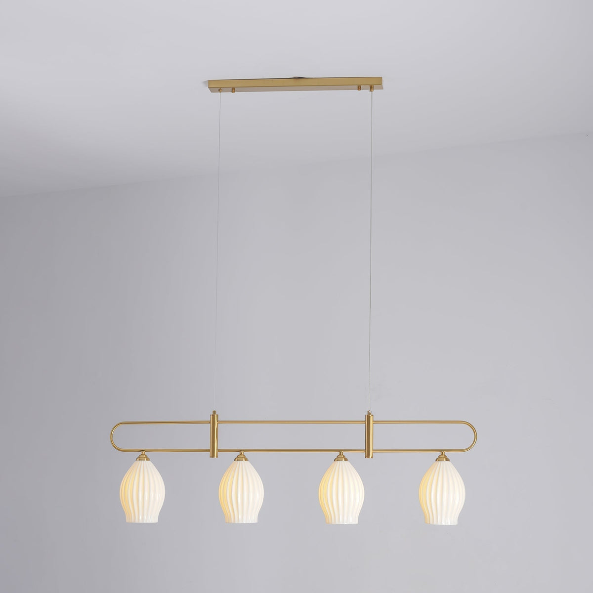Lámpara colgante lineal de cerámica Gajela – cobre de cuatro luces encendida