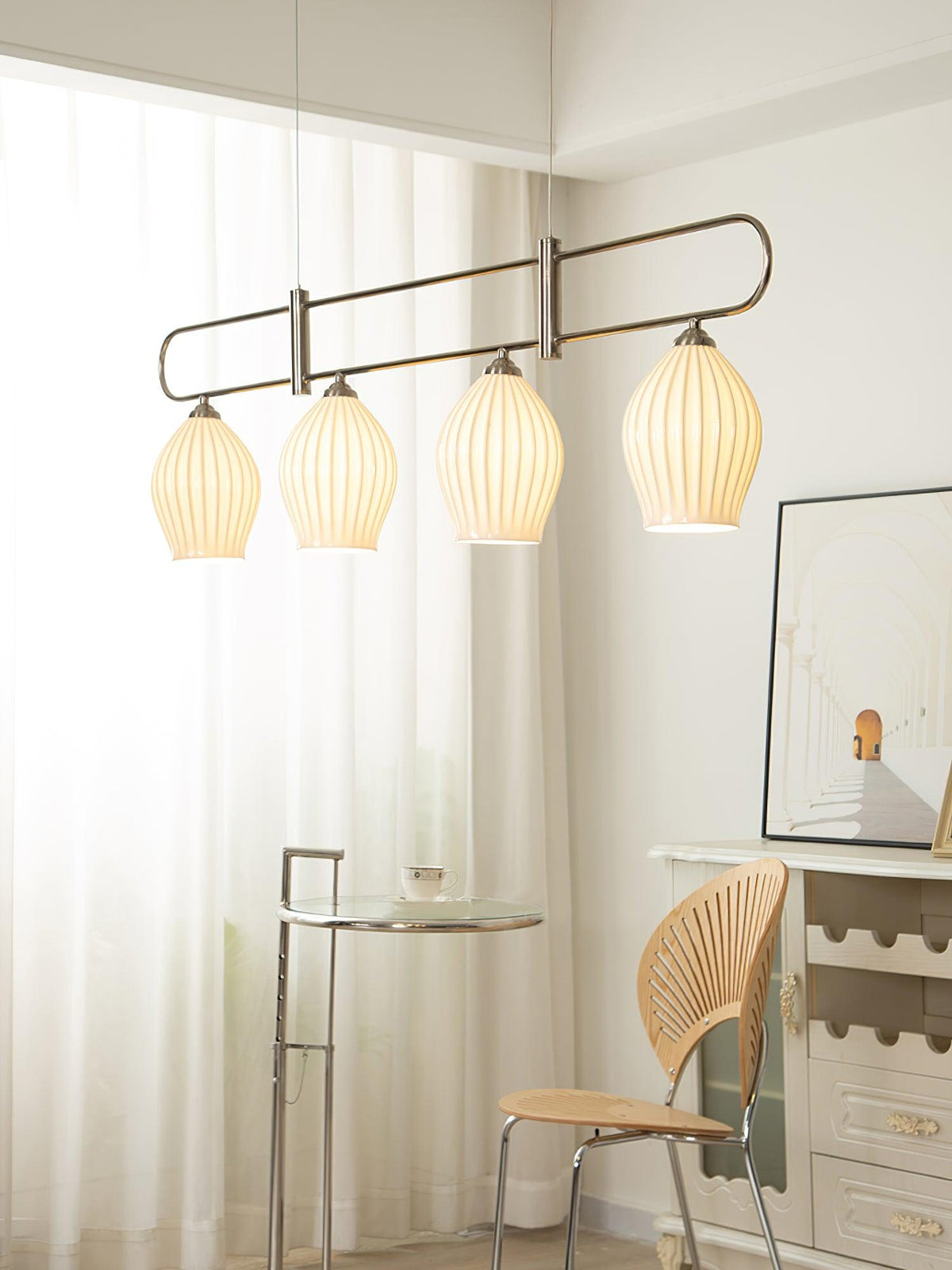 Lámpara colgante lineal de cerámica Gajela – níquel de cuatro luces junto a una ventana