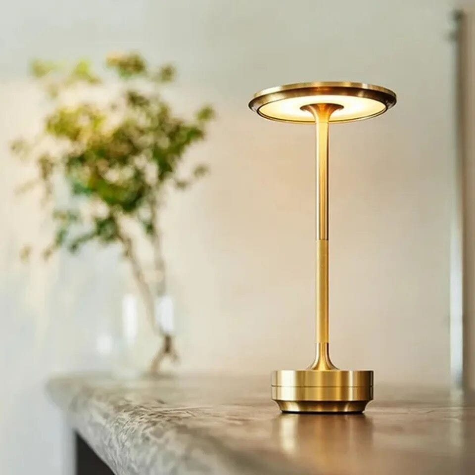 Lámpara de mesa portátil Raliza – versión dorada encendida sobre una encimera