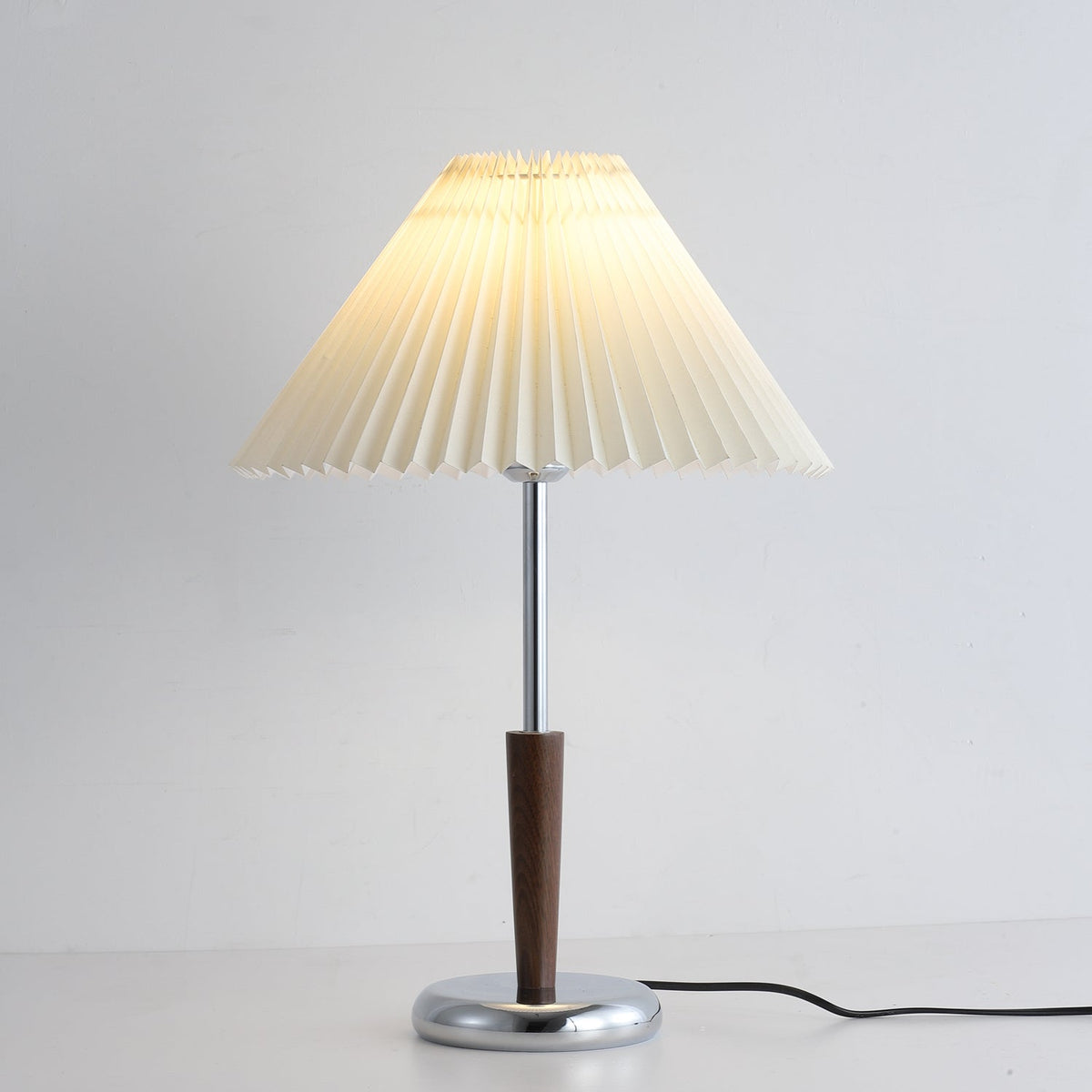 Lámpara de mesa con pantalla plisada Ivenna – detalle de la base cromada redonda