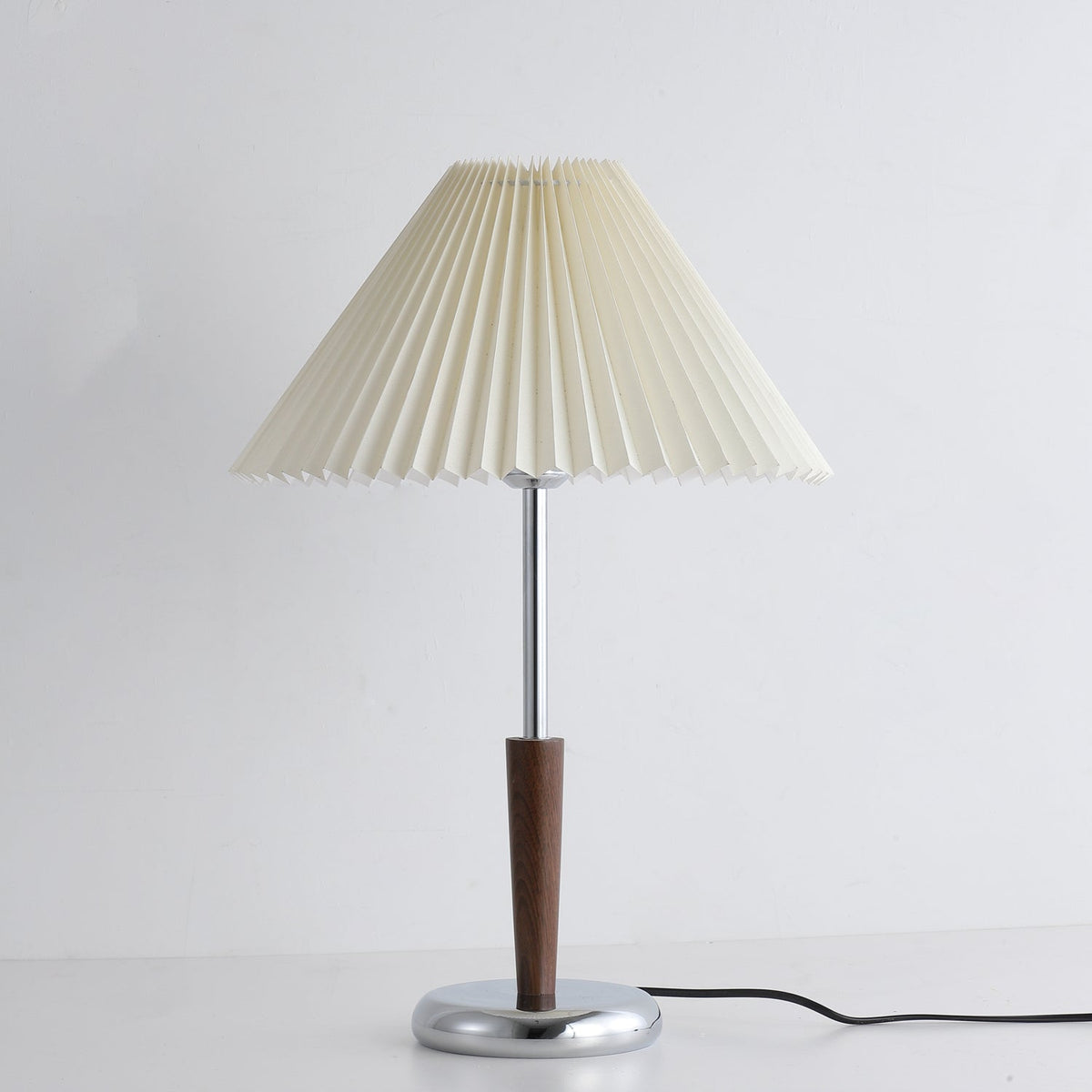 Lámpara de mesa con pantalla plisada Ivenna – en un rincón de lectura
