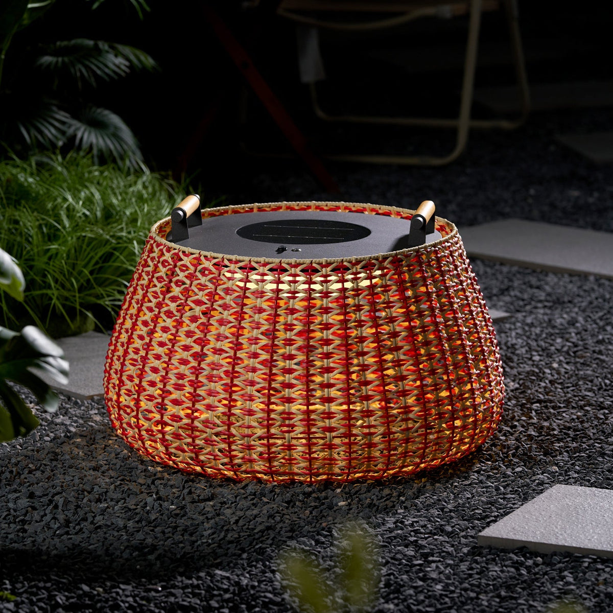 Farol de suelo solar Jalesca – encendido en un jardín de grava
