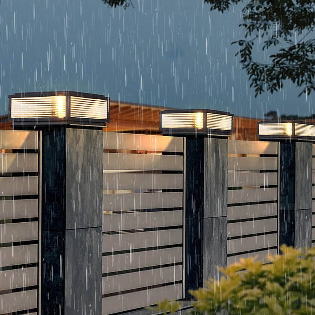 Lámpara de pilar exterior Jondela – sobre los pilares de una valla bajo la lluvia