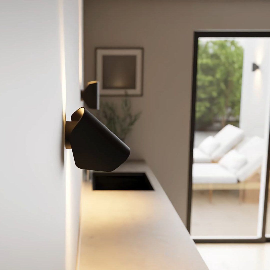 Aplique de pared orientable Jovira – negro inclinado sobre una encimera