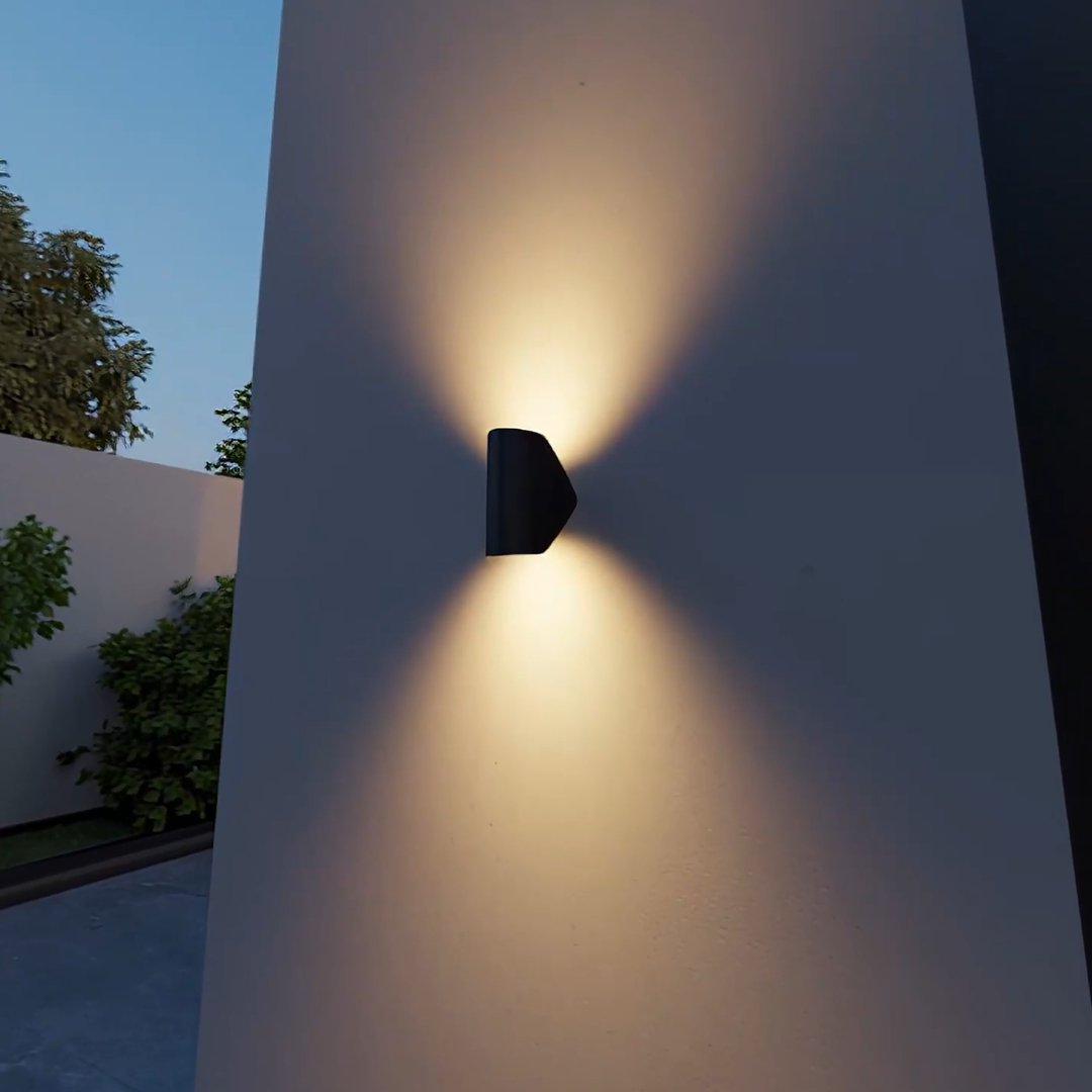 Aplique de pared orientable Jovira – negro en una pared exterior al anochecer