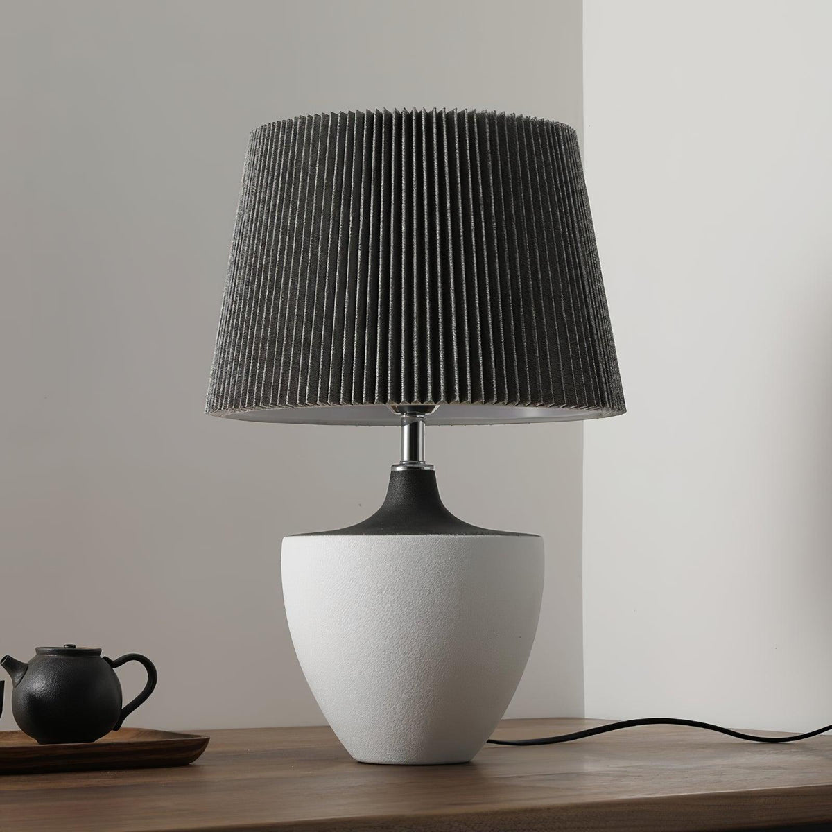 Lámpara de mesa de cerámica Kavera – versión alta de 49 cm encendida sobre la mesa