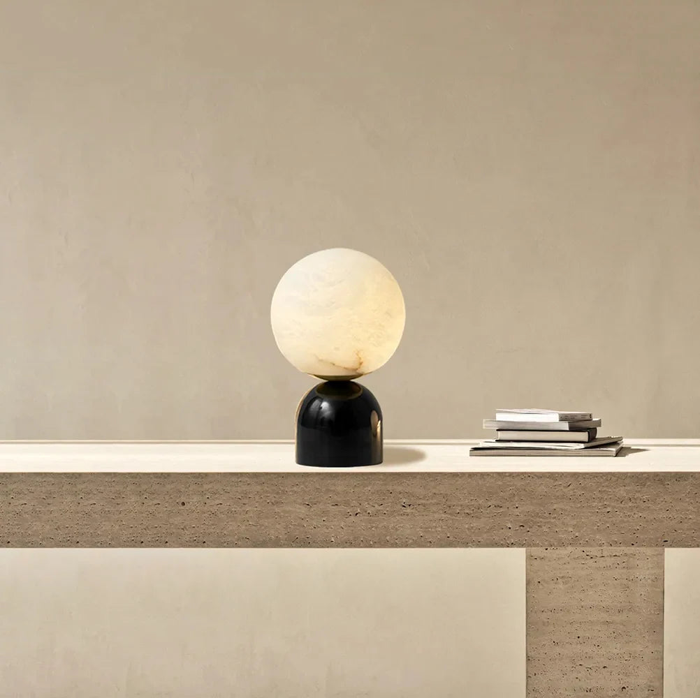 Lámpara de mesa de alabastro Kelaria – apagada junto a libros y cerámica