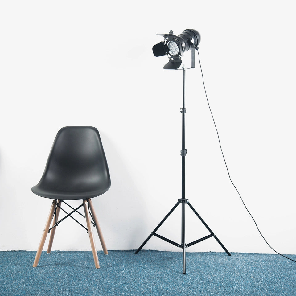 Lámpara de pie trípode Pelora estilo foco de estudio – junto a una silla