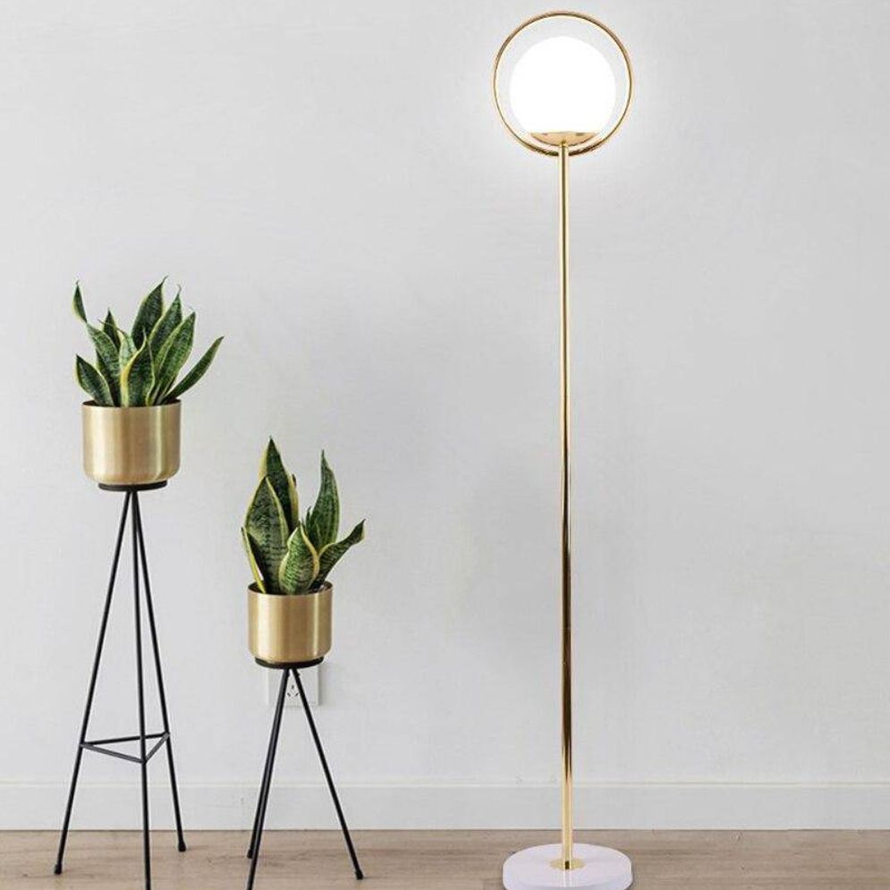 Lámpara de pie globo de cristal con aro dorado Soluna – junto a plantas